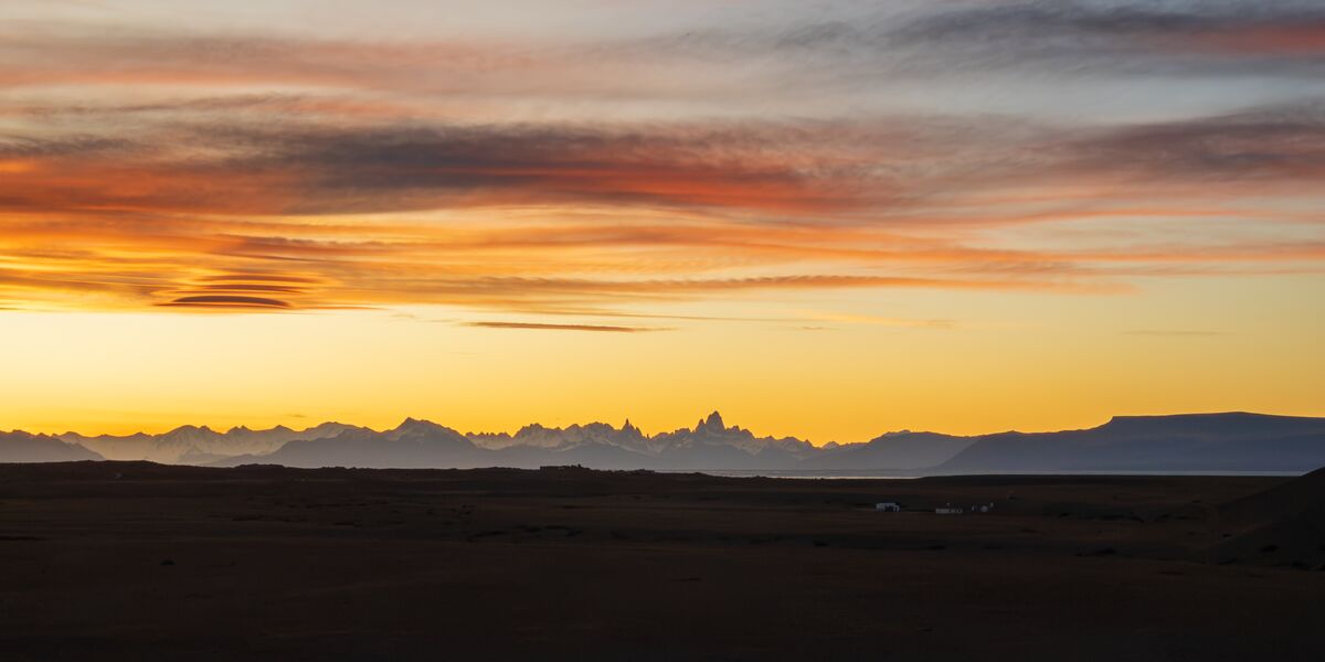 Sunset over the Patagonian steppe with the outline of Mount Fitz Roy and the Andes on the horizon, seen from Route 40
