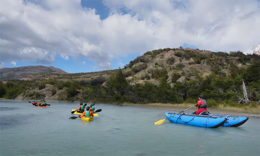 Kayaks and a support boat among the native forest