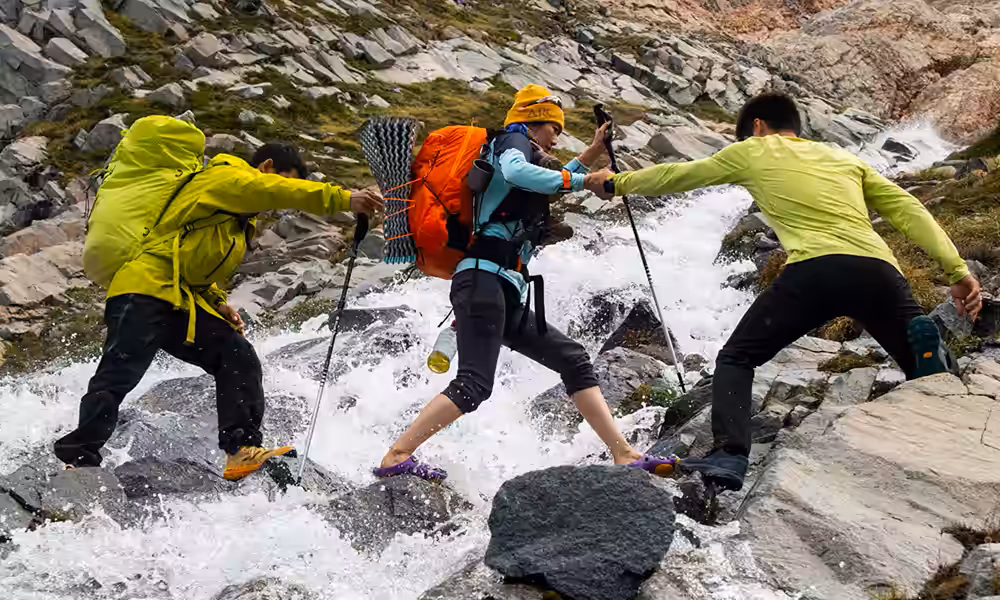 Grupo de fotógrafos cruzando un arroyo de montaña