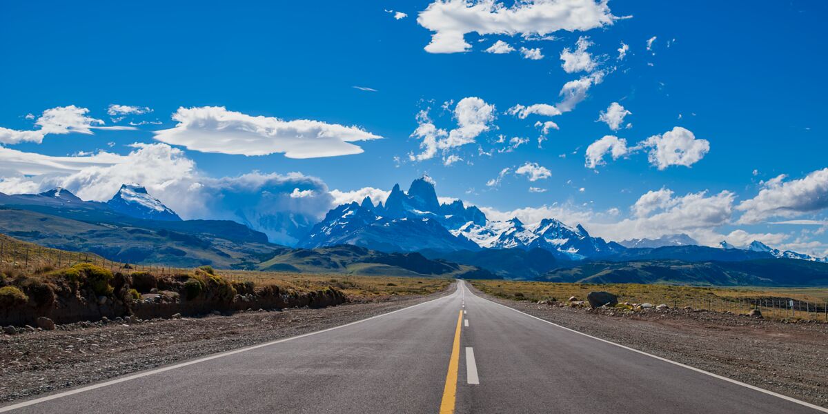 Paved Provincial Route 41 running straight toward the snow-capped Fitz Roy massif under a blue sky